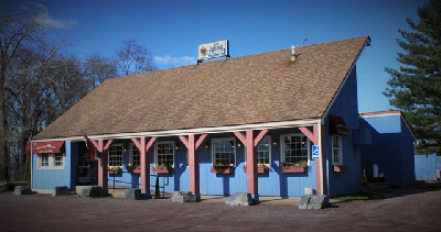 倾斜屋顶的建筑，漆成蓝色，有带顶棚的走道和窗框.